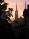 Church spires through mist at sunrise.