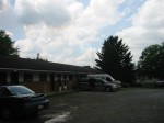 Front of motel with cars and trees